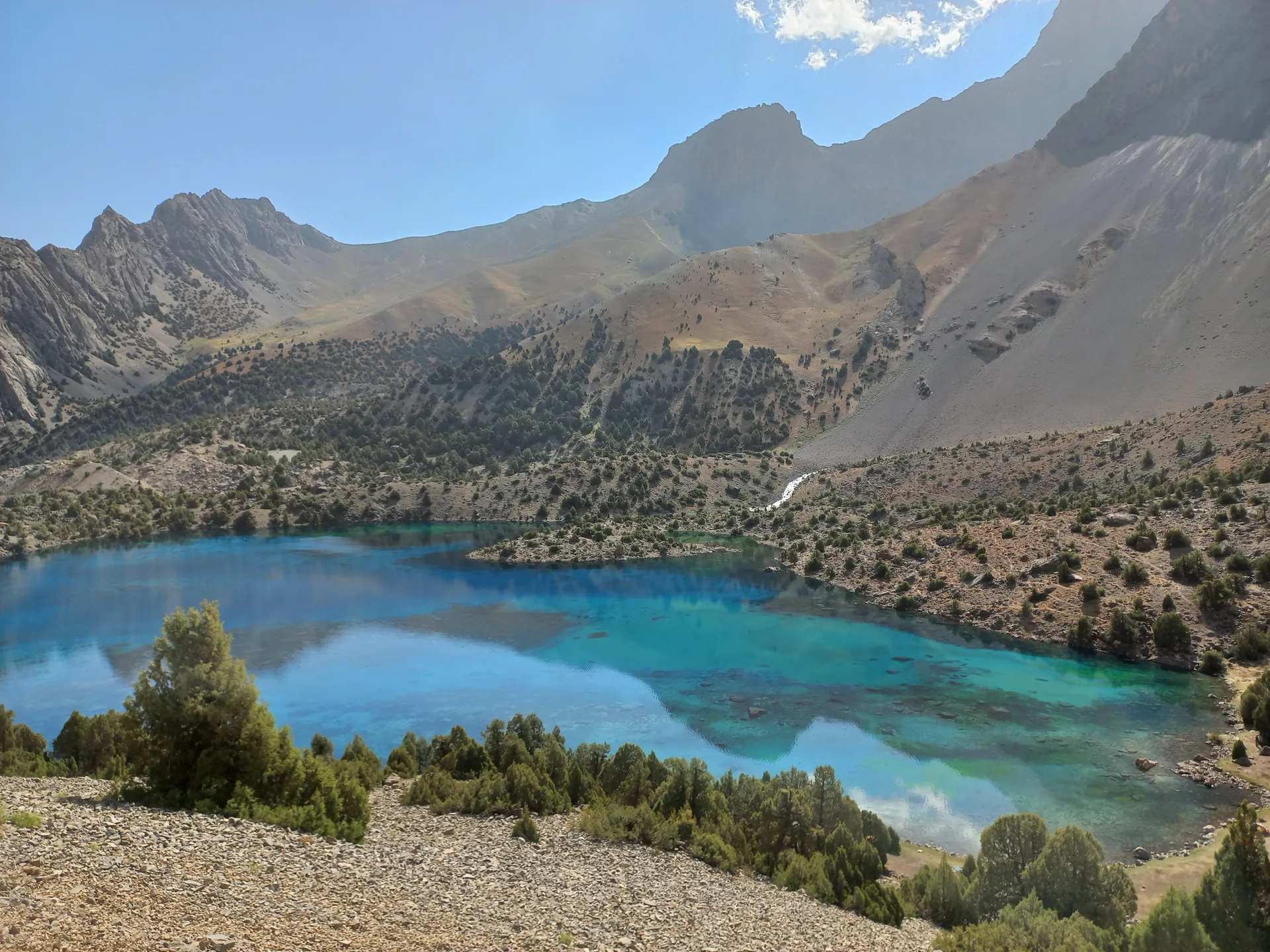 High mountain trail and alpine lake scenery in the Fann Mountains